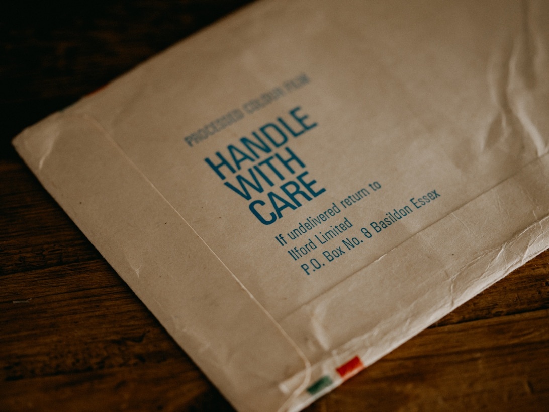 En brun fraktkartong med texten 'HANDLE WITH CARE' tryckt tydligt, vilket representerar noggrann fraktpraxis.
